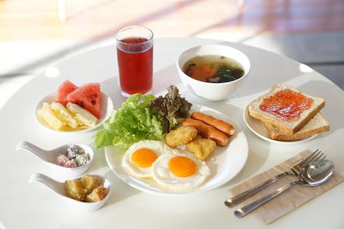 een witte tafel met een bord ontbijtproducten bij Passion Resort Kiriwong in Kiriwong