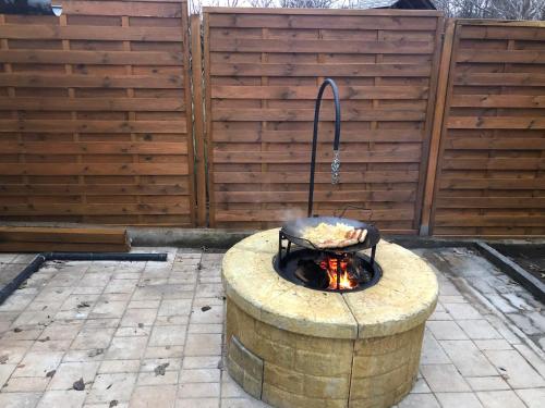 a fire pit in a backyard with a grill at Respect Apartament in Hévíz