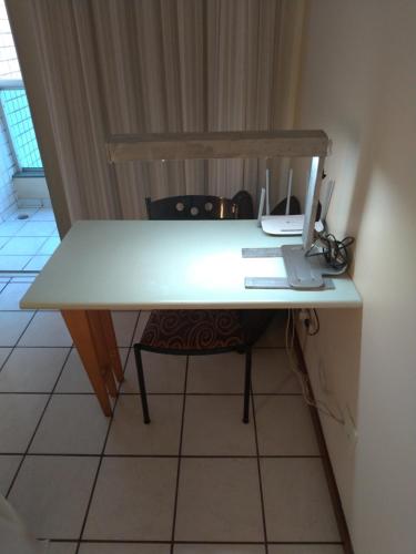 a white desk with a chair in a room at Apart Hotel Quartier Latin in Vitória