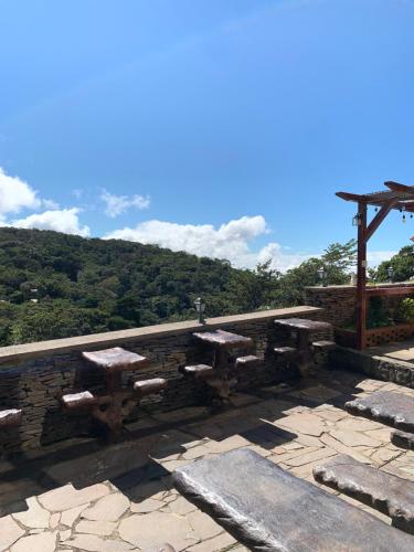 a stone wall with picnic tables on top of it at Cabinas Vista Al Golfo in Monteverde Costa Rica