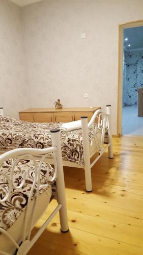uma cama branca num quarto com piso em madeira em Guest House Family Inn em Tbilisi