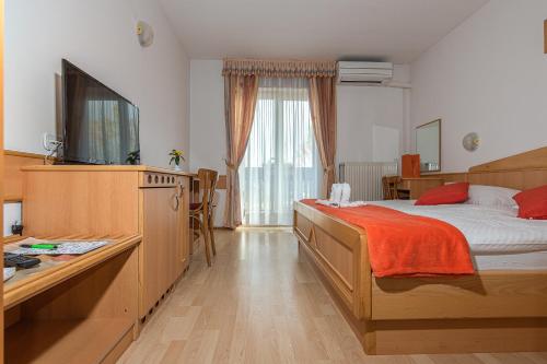 1 dormitorio con 1 cama y TV en una habitación en Gostisce Golob, en Zgornja Polskava