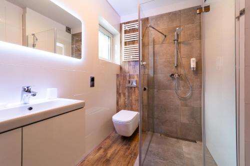 een badkamer met een douche, een toilet en een wastafel bij Apartament z garażem "Widok na Skrzyczne" - Słoneczna Góra in Szczyrk