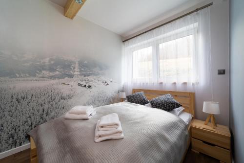 een slaapkamer met een bed met twee handdoeken erop bij Apartament z garażem "Widok na Skrzyczne" - Słoneczna Góra in Szczyrk