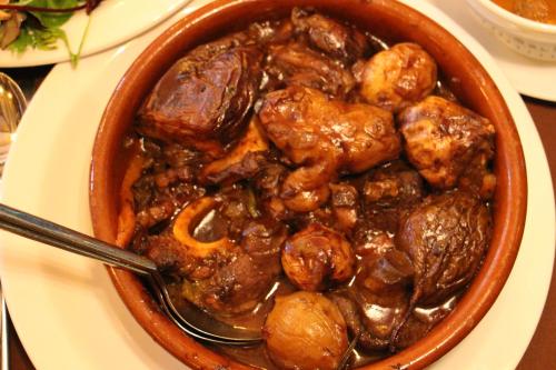 a bowl of food with meat and mushrooms on a table at Shavit Simple room in Arbel