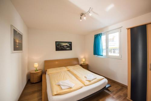 a bedroom with a bed with two pillows on it at Alpenblick - Direct lake view in Brienz