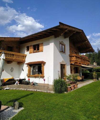 a white house with wooden windows and a yard at Marie Luise, Landhaus in Reith bei Kitzbühel