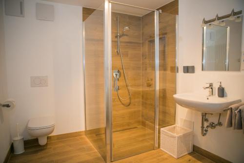 een badkamer met een douche, een toilet en een wastafel bij Ferienwohnungen Schnabel im Herzen von Rottach-Egern in Rottach-Egern