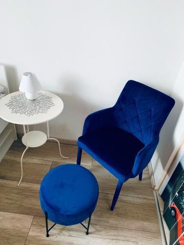 a blue chair and a stool next to a table at Parkowy Kudowa in Kudowa-Zdrój