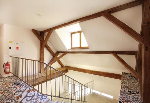 a staircase in a loft with wooden beams at Cett in Náměšť nad Oslavou