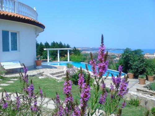 a garden with purple flowers in front of a house at Villa Sky Music in Obzor