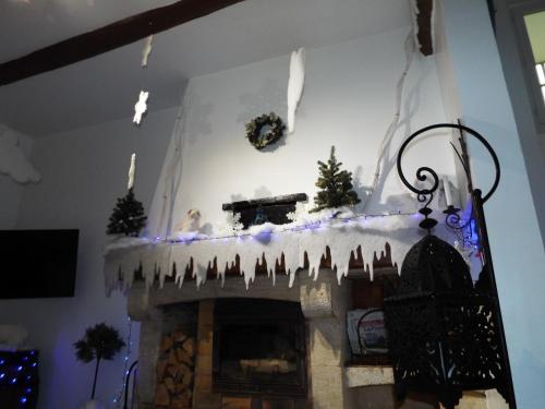 a fireplace with christmas decorations on the mantle at La Maison du Moulin de Tartay in Avignon