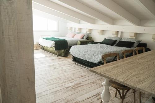 Habitación con 2 camas y mesa con sillas. en Attico 72 en Matera