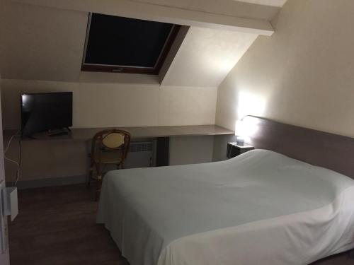 - une chambre avec un lit blanc et une télévision à écran plat dans l'établissement Hôtel Restaurant De La Mare, à Avrigny