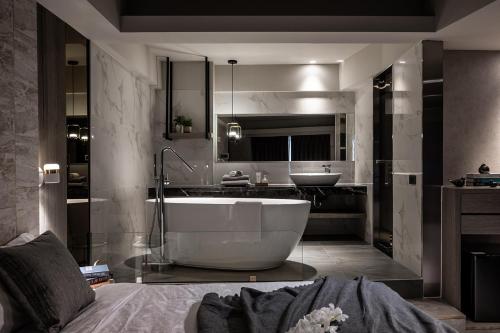 a bathroom with a large tub and a sink at Two Easy Inn in Jiufen