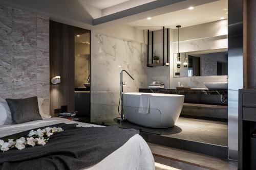 um quarto com uma banheira e uma casa de banho em Two Easy Inn em Jiufen