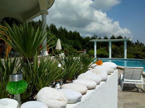 a row of rocks sitting next to a swimming pool at Villa Sky Music in Obzor