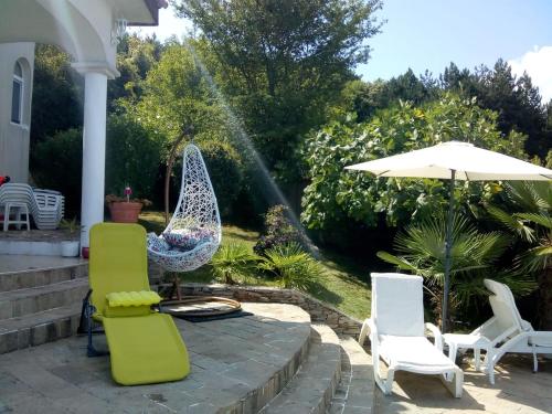 a patio with two lawn chairs and an umbrella at Villa Sky Music in Obzor