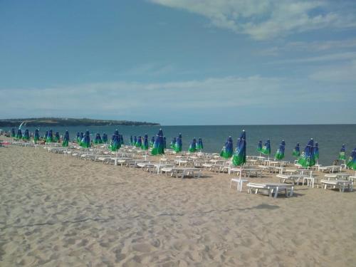 a group of chairs and umbrellas on a beach at Villa Sky Music in Obzor