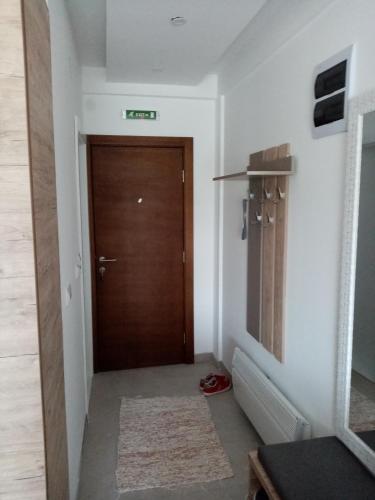 a hallway with a wooden door with a rug at Pčelica L15 Milmari in Kopaonik
