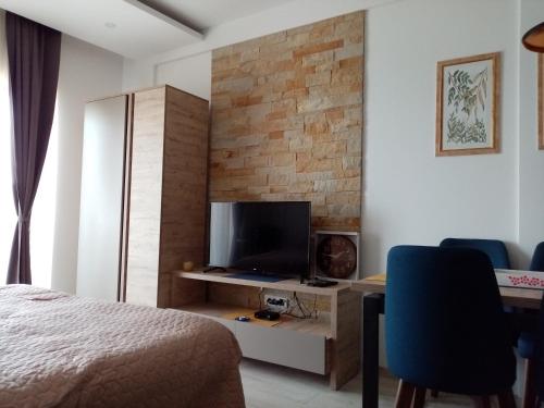 a bedroom with a bed and a desk with a television at Pčelica L15 Milmari in Kopaonik