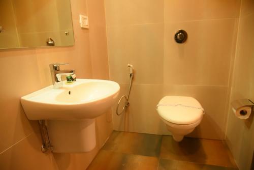 a bathroom with a sink and a toilet at Hotel Tea City in Dibrugarh