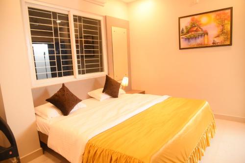 a bedroom with a large bed and a window at Hotel Tea City in Dibrugarh