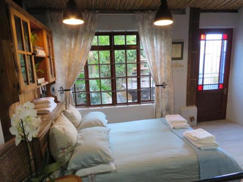 sypialnia z dużym łóżkiem i dużym oknem w obiekcie Winelands beach cottage w Kapsztadzie