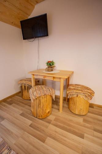 a table and stools in a room with a television at Penzión Natália in Terchová