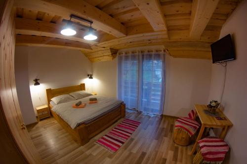 a bedroom with a bed and a television and a table at Penzión Natália in Terchová