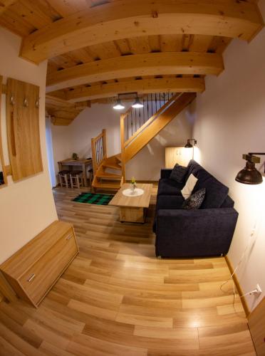 a living room with a black couch and wooden floors at Penzión Natália in Terchová