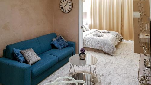 ein Wohnzimmer mit einem blauen Sofa und einem Bett in der Unterkunft Apartmán LIANA Hrebienok C107 in Starý Smokovec