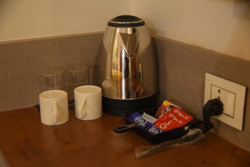 a kitchen counter with a coffee maker and two cups at Hotel Tea City in Dibrugarh
