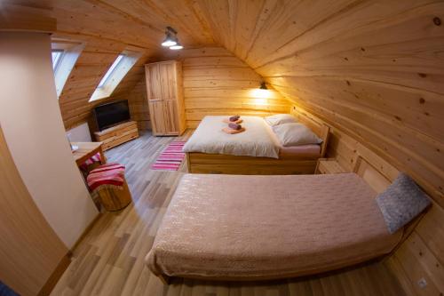 a room with two beds in a log cabin at Penzión Natália in Terchová