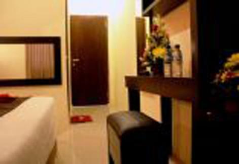 a room with a chair and a door with flowers at Asher Bali Transit in Kuta