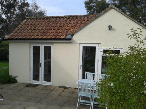 a small white house with a table in front of it at Yew Tree View in Marnhull