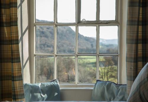 a window in a bedroom with a view of a mountain at Witherslack Hall Farmhouse in Grange Over Sands