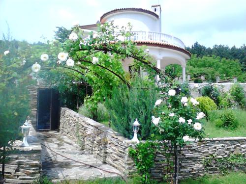 a house with a stone fence and a building at Villa Sky Music in Obzor