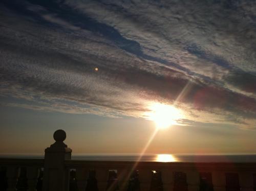 a sunset over the ocean with a statue in the foreground at Villa Sky Music in Obzor