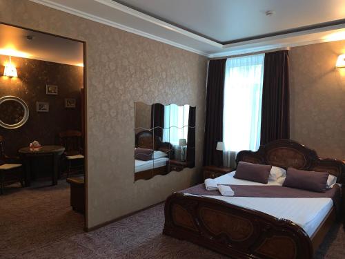モスクワにあるLefortovsky Dvorik Hotelのベッドと鏡が備わるホテルルーム