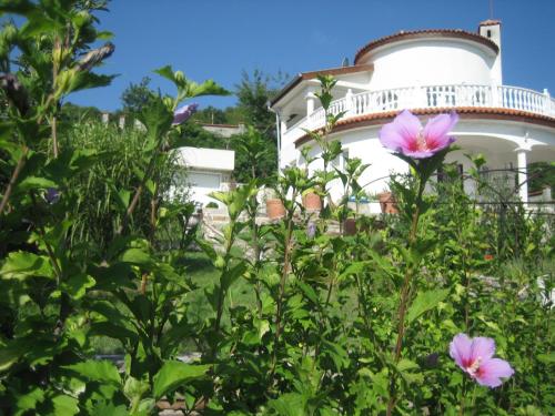a white house with a pink flower in front of it at Villa Sky Music in Obzor