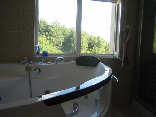 a bathroom with a bath tub and a window at Villa Sky Music in Obzor