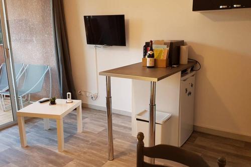 Cette chambre comprend une table et une petite table avec une chaise. dans l'établissement Studio Résidence Les Oliviers, à Balaruc-les-Bains