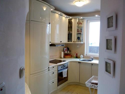 a kitchen with white cabinets and a refrigerator at Villa Sky Music in Obzor