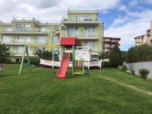 a playground in a yard in front of a building at Villa St Anna in Sozopol