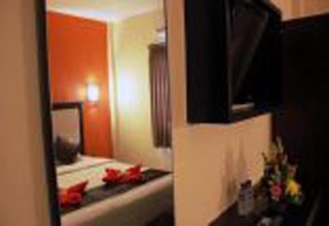 a reflection of a hotel room with a bed in a mirror at Asher Bali Transit in Kuta