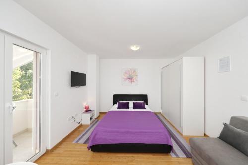 a bedroom with a bed and a couch at Lavanda Apartments in Sveti Petar