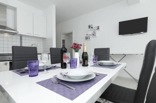 a white table with wine bottles and glasses on it at Lavanda Apartments in Sveti Petar