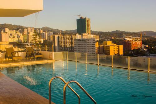 una piscina en la parte superior de un edificio con ciudad en Mabolo Garden Flat A8 free rooftop infinity pool, en Cebú