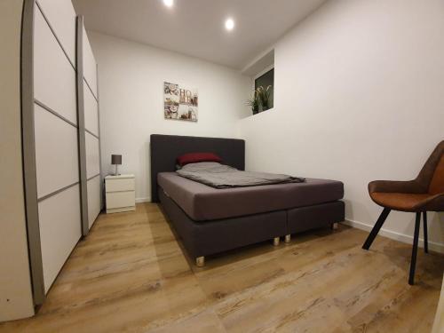 ラーティンゲンにある1 Zimmer Apartment Ratingen Ostの小さなベッドルーム(ベッド1台、椅子付)